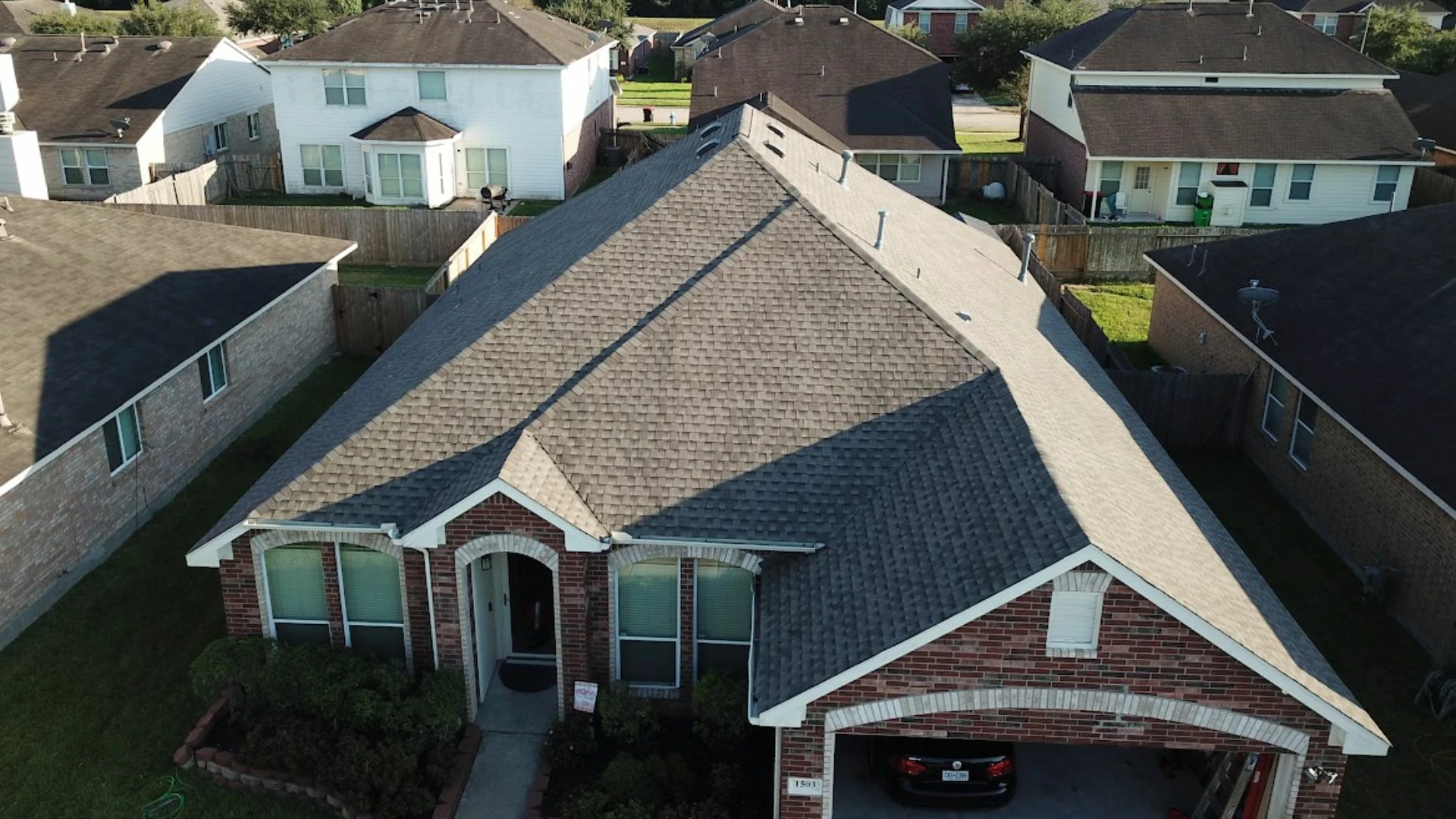 Aerial view of a residential roof undergoing drone roof inspections by Achilles Roofing & Exterior