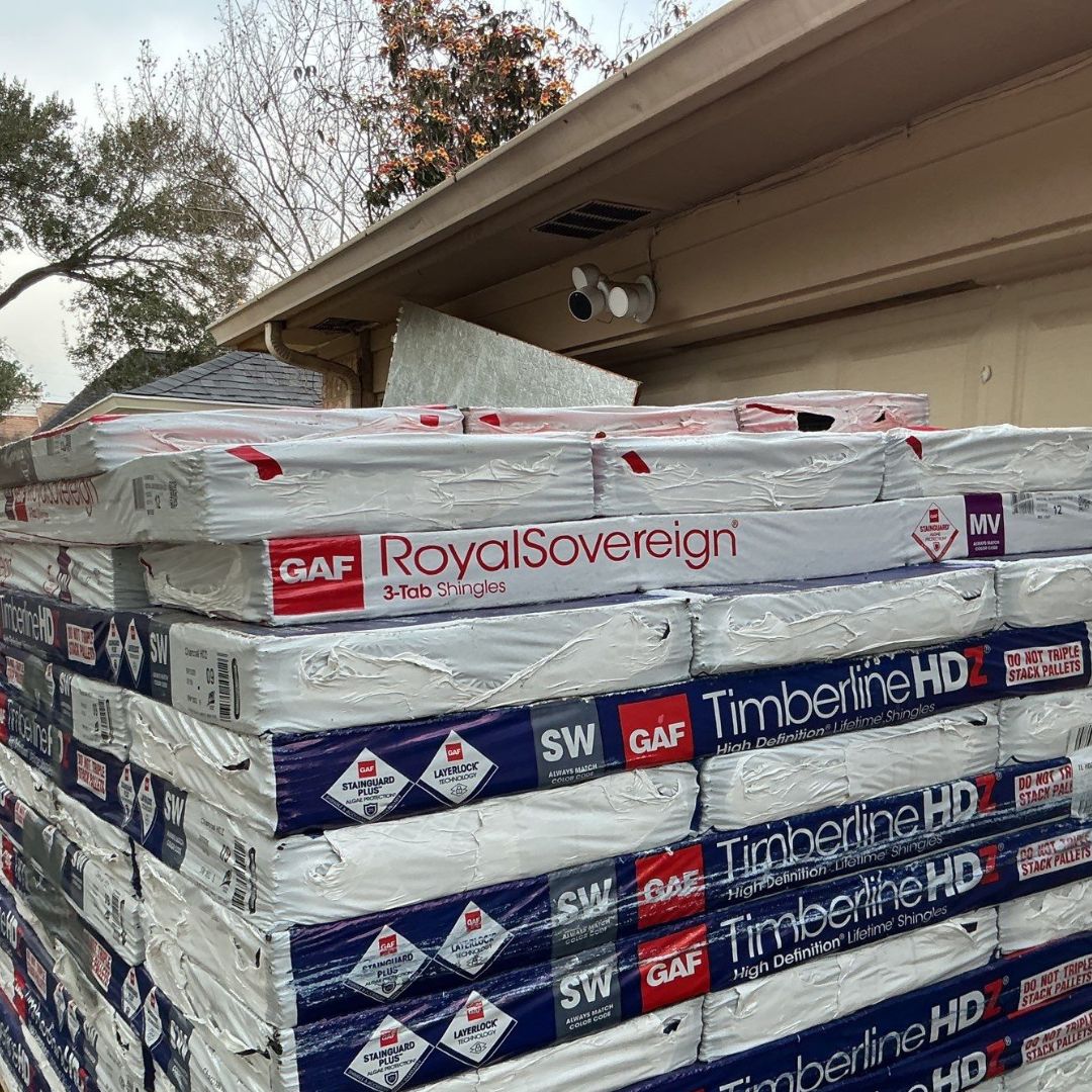 Stacked GAF roofing shingles delivered for a residential roof replacement project by Achilles Roofing