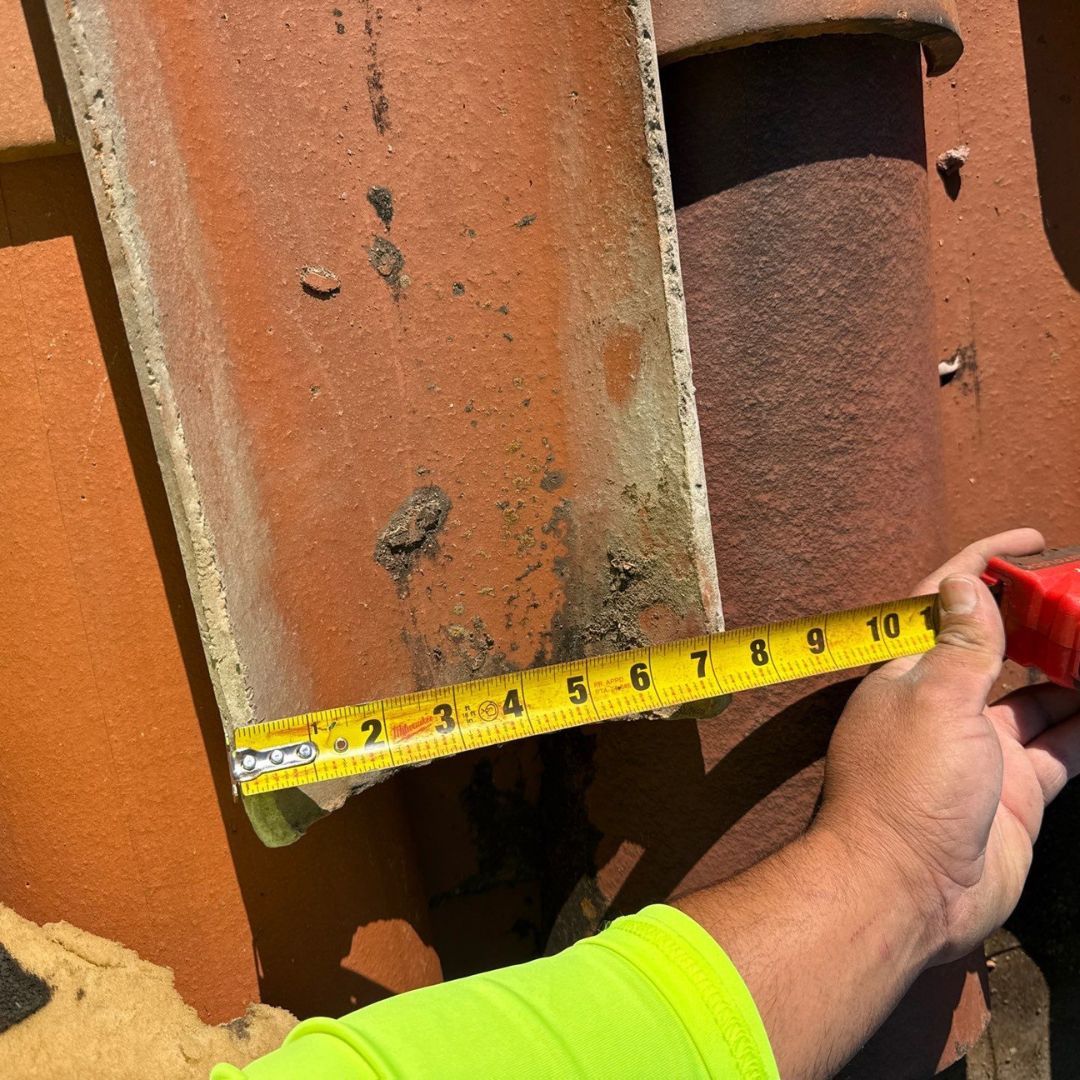 Roofing contractor measuring wood decking during a roof repair inspection by Achilles Roofing & Exterior