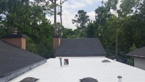 Quality roof repair in Houston featuring new shingles and a reflective flat roof for better durability and energy efficiency.