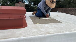 A detailed view of a skilled roofer meticulously sealing a difficult penetration point on a commercial or residential flat roof membrane. Improperly sealing these areas is a common source of water intrusion and major roof repair mistakes. The image promotes the technical skill required to ensure the long-term integrity of the roofing system.