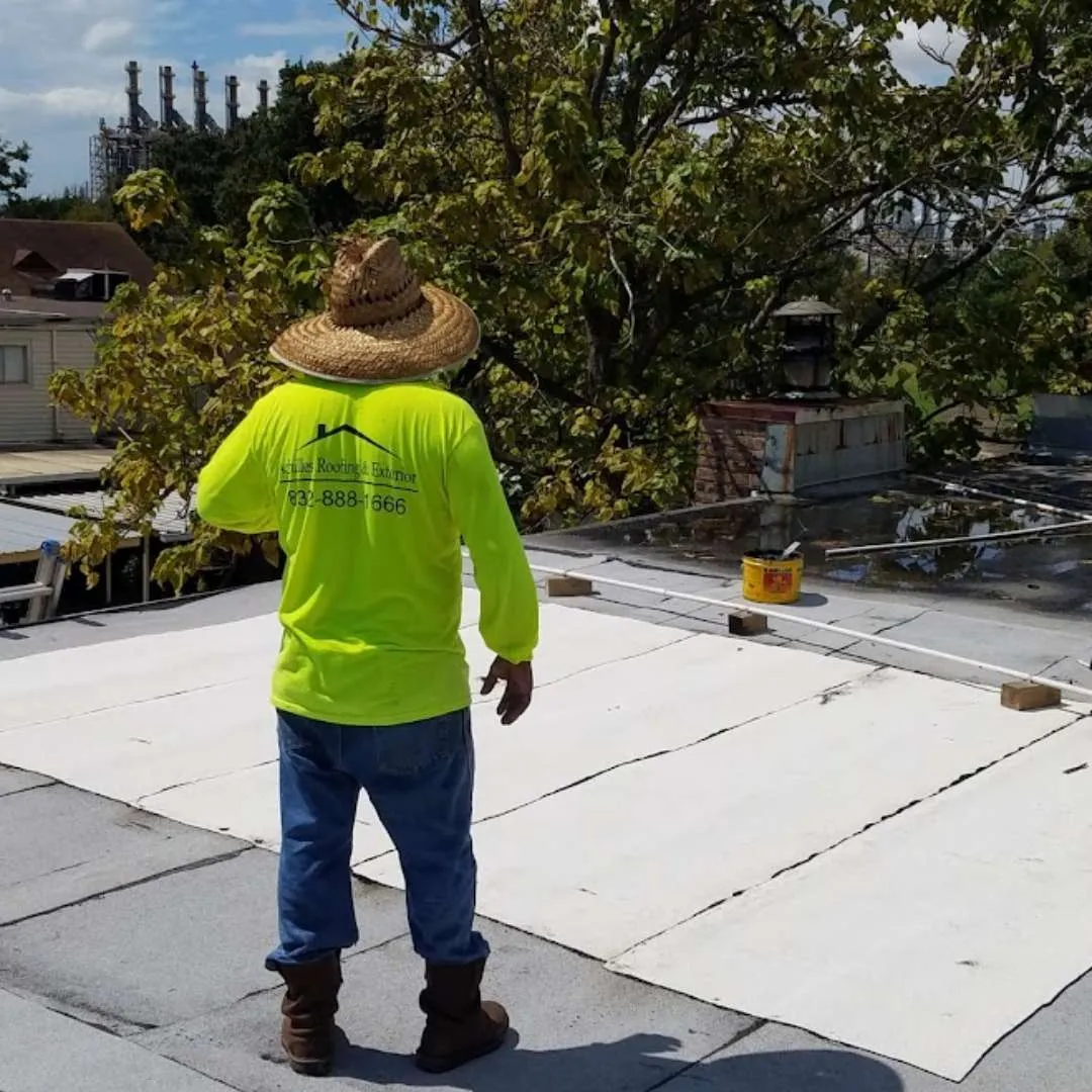 Commercial roofing contractor inspecting a commercial modified bitumen roof installation by Achilles Roofing & Exterior