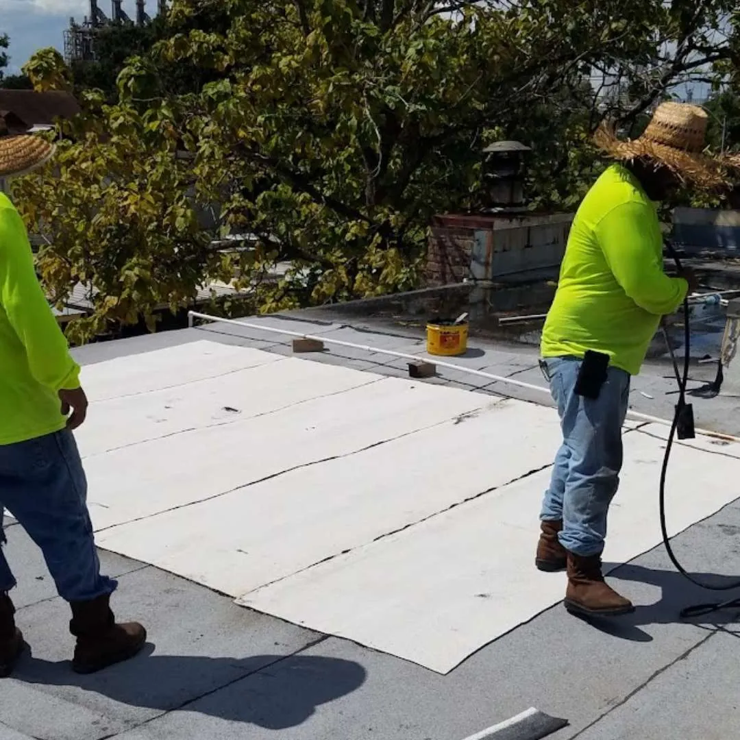 Roofing contractors installing commercial modified bitumen membrane on a flat roof by Achilles Roofing & Exterior