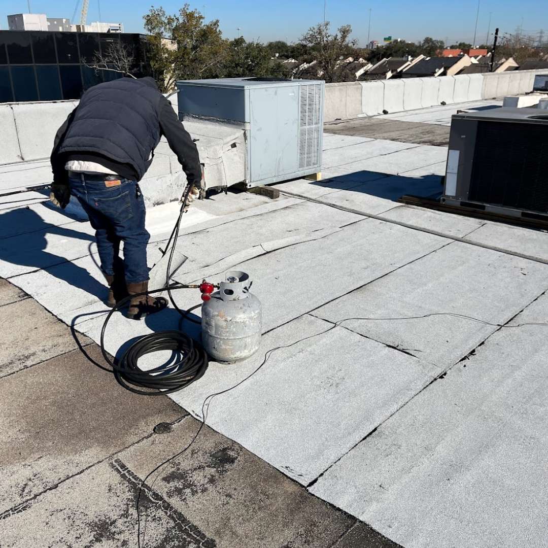 Roofing contractor torch-applying commercial modified bitumen membrane by Achilles Roofing & Exterior
