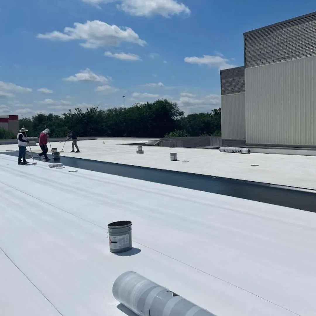 Commercial roofing crew inspecting and laying flat roof membrane during a commercial roof replacement by Achilles Roofing & Exterior