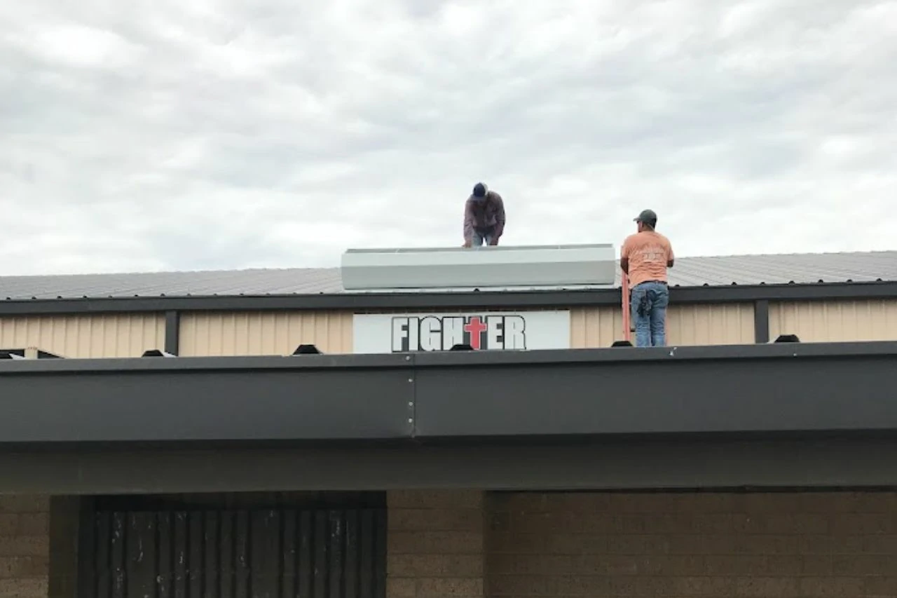 Professional roofing technicians inspecting roof deck transition points during a flashing repair project by Achilles Roofing & Exterior