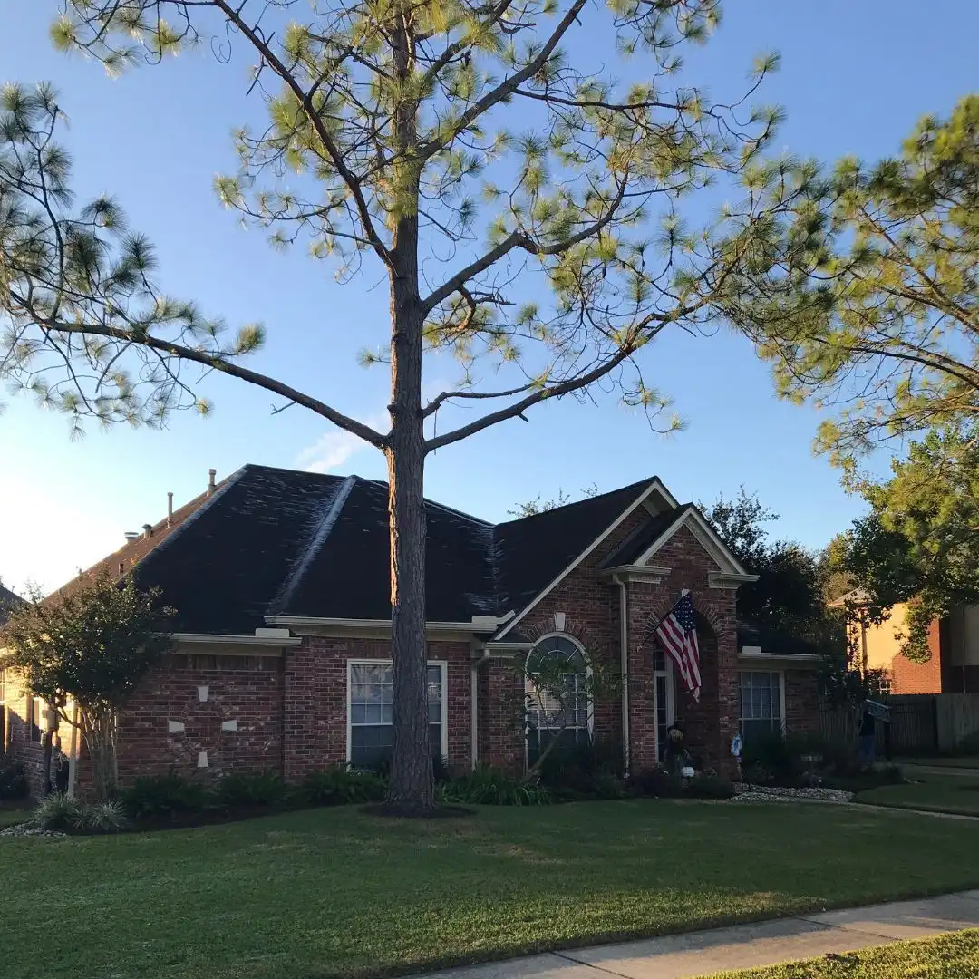 Two-story residential brick house with asphalt shingle roof inspected for asphalt shingle repair by Achilles Roofing & Exterior