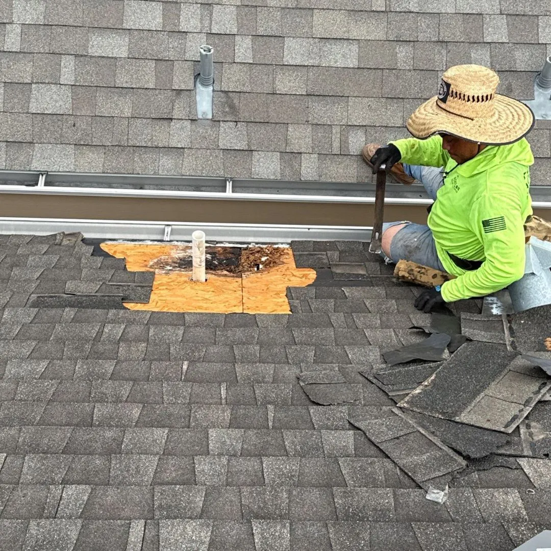 Roofing contractor repairing water-damaged decking around a pipe vent during a roof leak repair by Achilles Roofing & Exterior