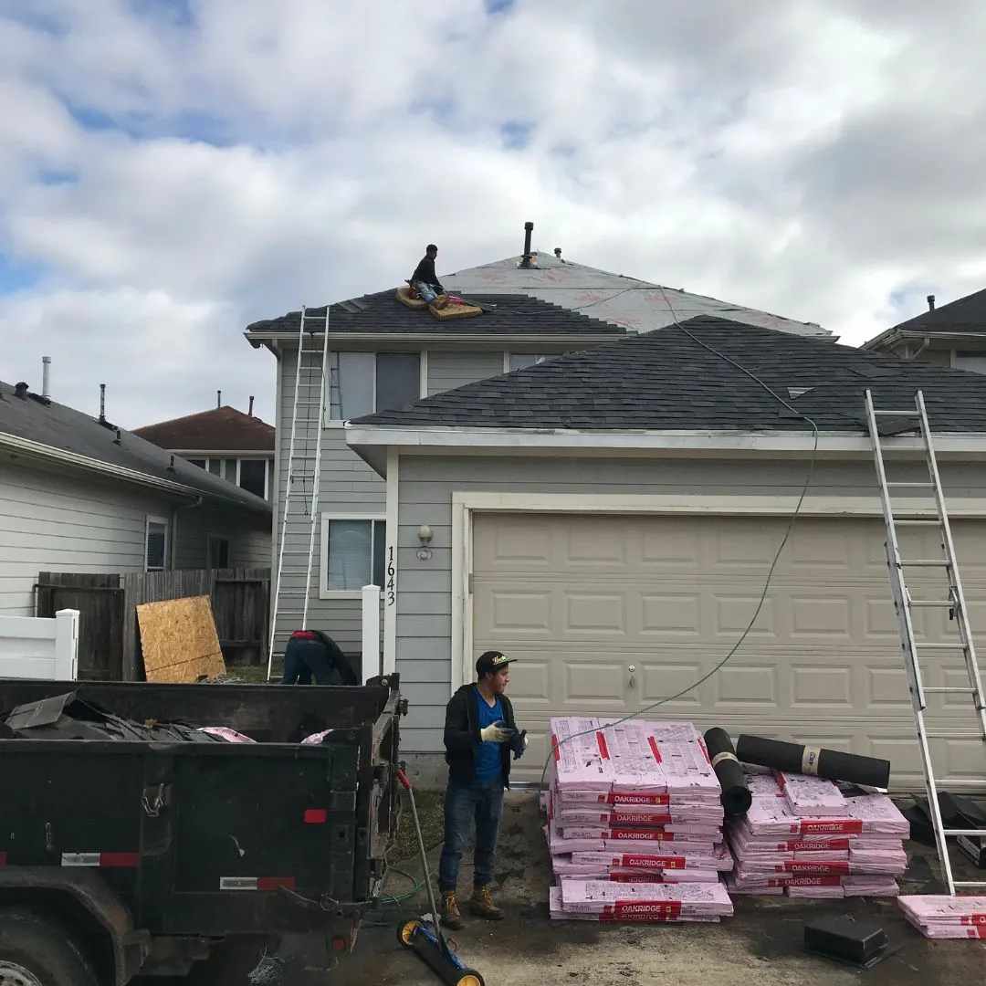 Professional roofing crew performing shingle repair and roof tear-off on a residential property by Achilles Roofing & Exterior