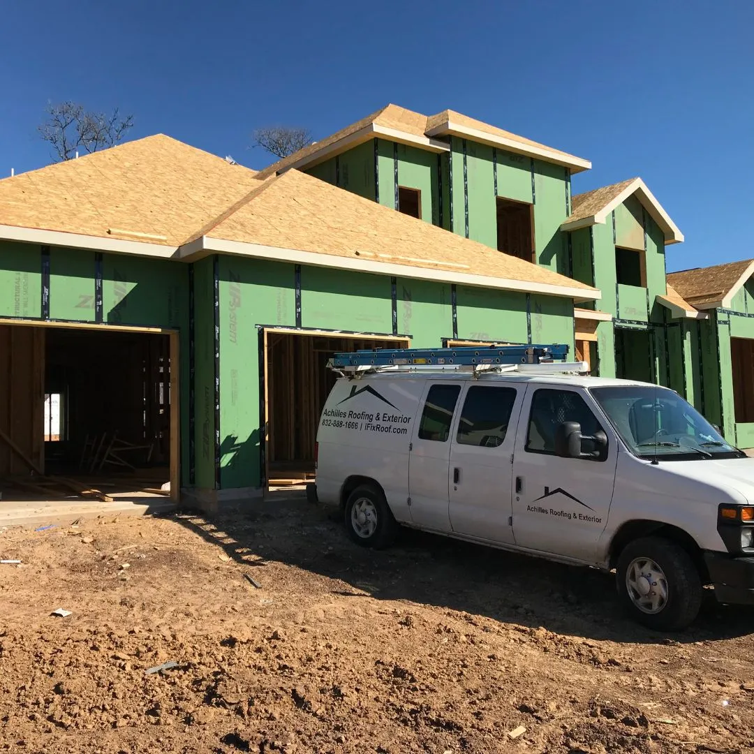 Achilles Roofing & Exterior service van on-site for a complete roof replacement and installation on a new Houston home