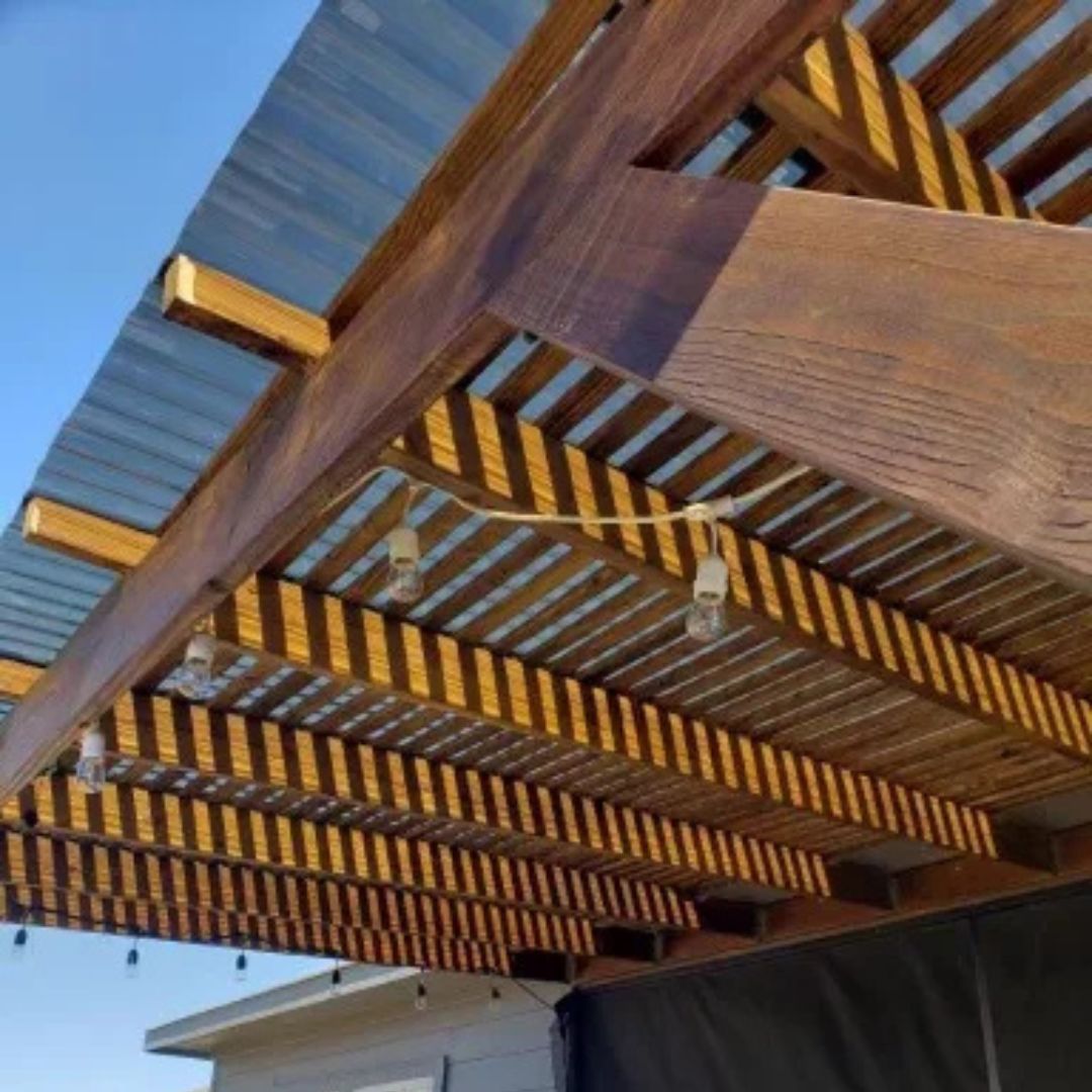 Custom wooden pergola framing and structural overhang inspected for commercial canopy installation by Achilles Roofing & Exterior