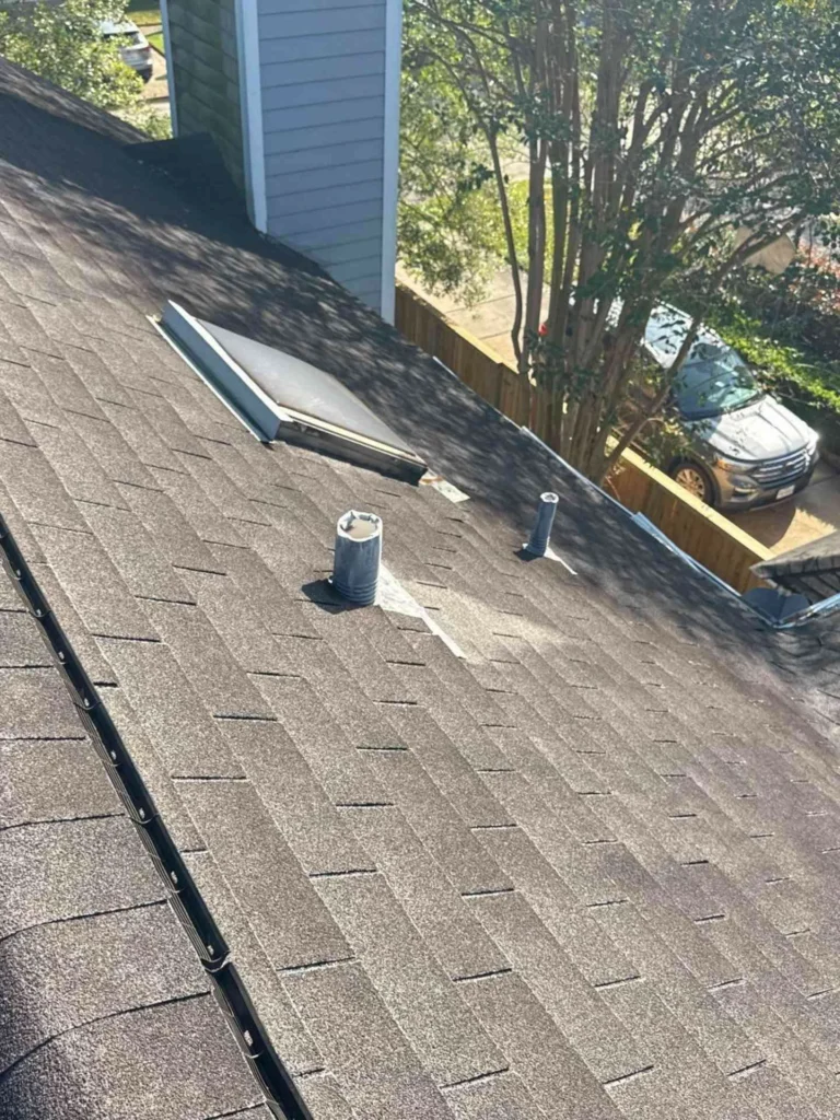This image shows a home in Houston with old, discolored shingles and visible roof vents before roof replacement.