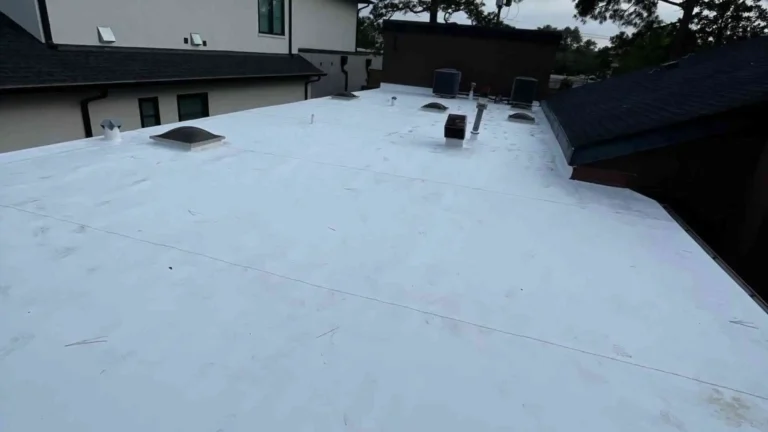 This image shows a newly retrofitted flat roof with a clean TPO (or PVC) membrane covering over the old roof substrate — ready to withstand Houston weather.