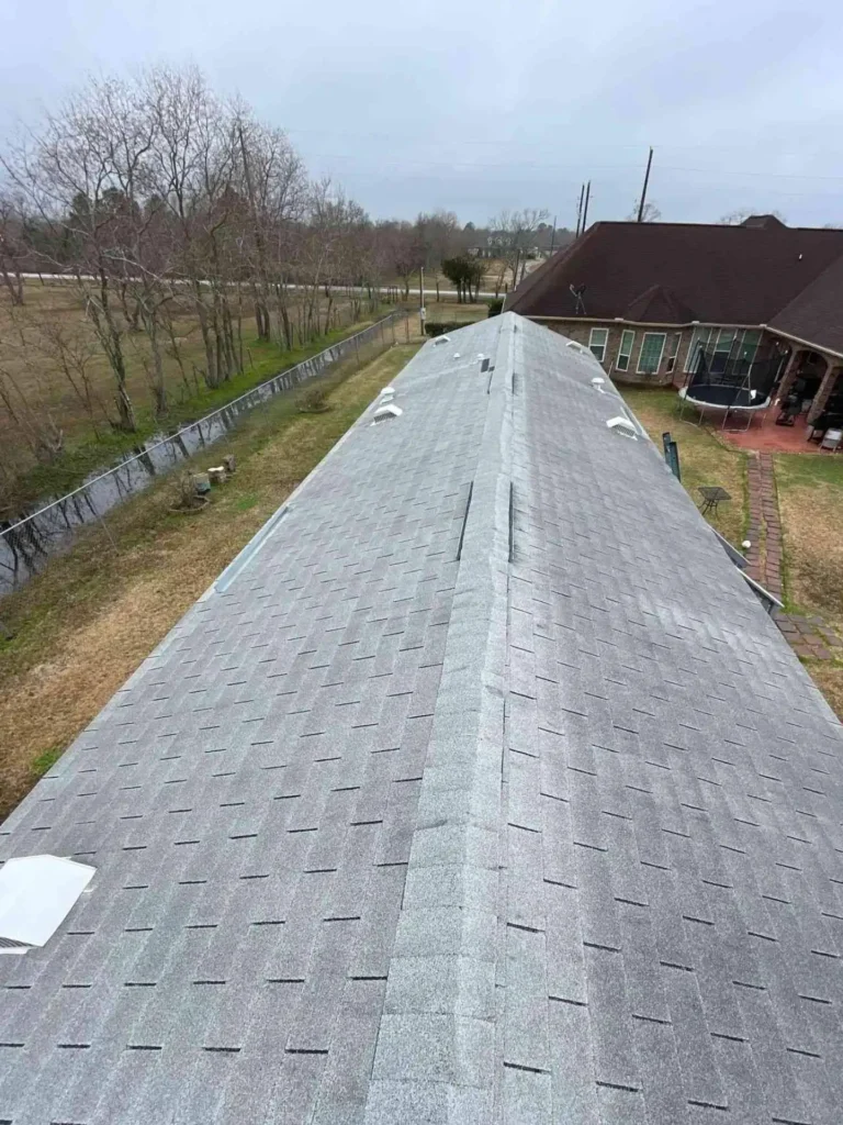 The picture presents an aerial or angled view of the completed roof replacement project on a Baytown, TX home — showcasing overall coverage and improved curb appeal.