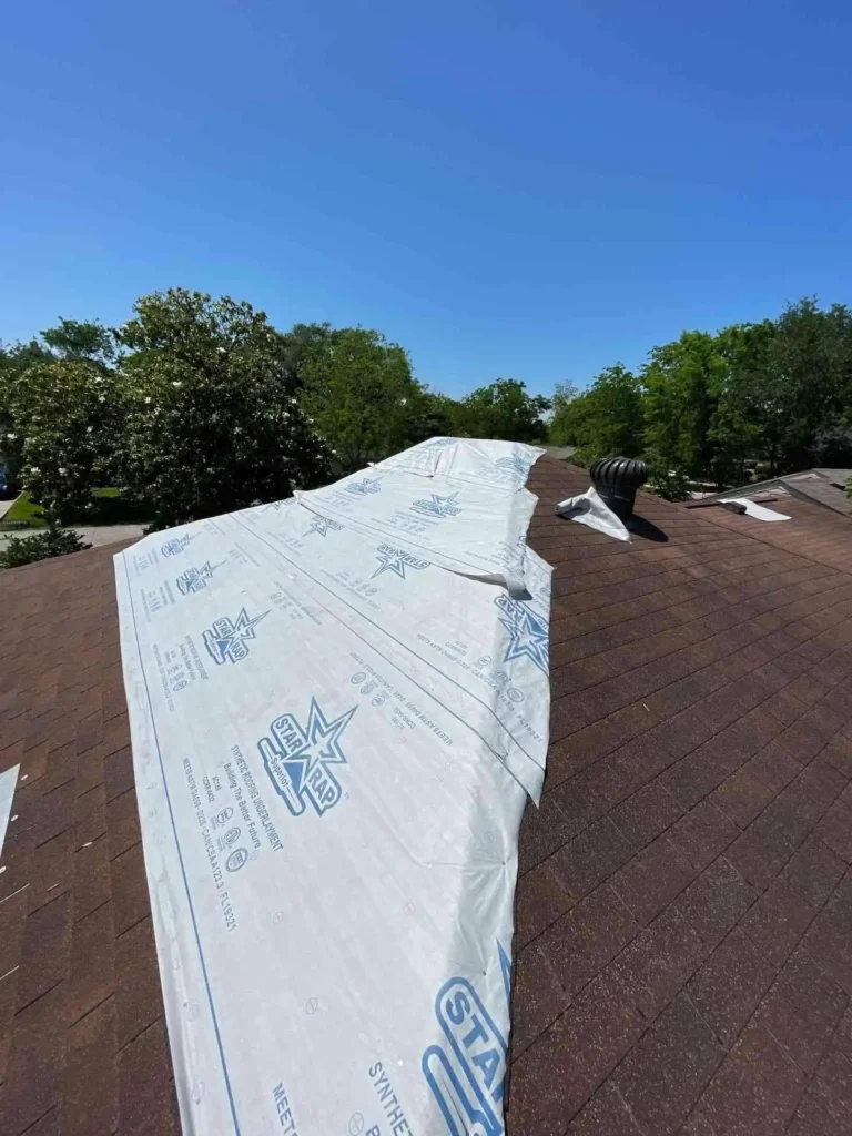 This image shows a professional Emergency Tarp Installation on a Houston, TX home after roof damage — the heavy-duty tarp is secured tightly over the affected area to prevent water intrusion.