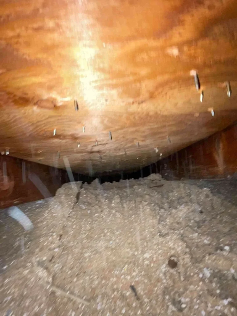 This image shows a very dusty, clogged soffit vent on a Webster TX home, with heavy dirt buildup blocking ventilation.