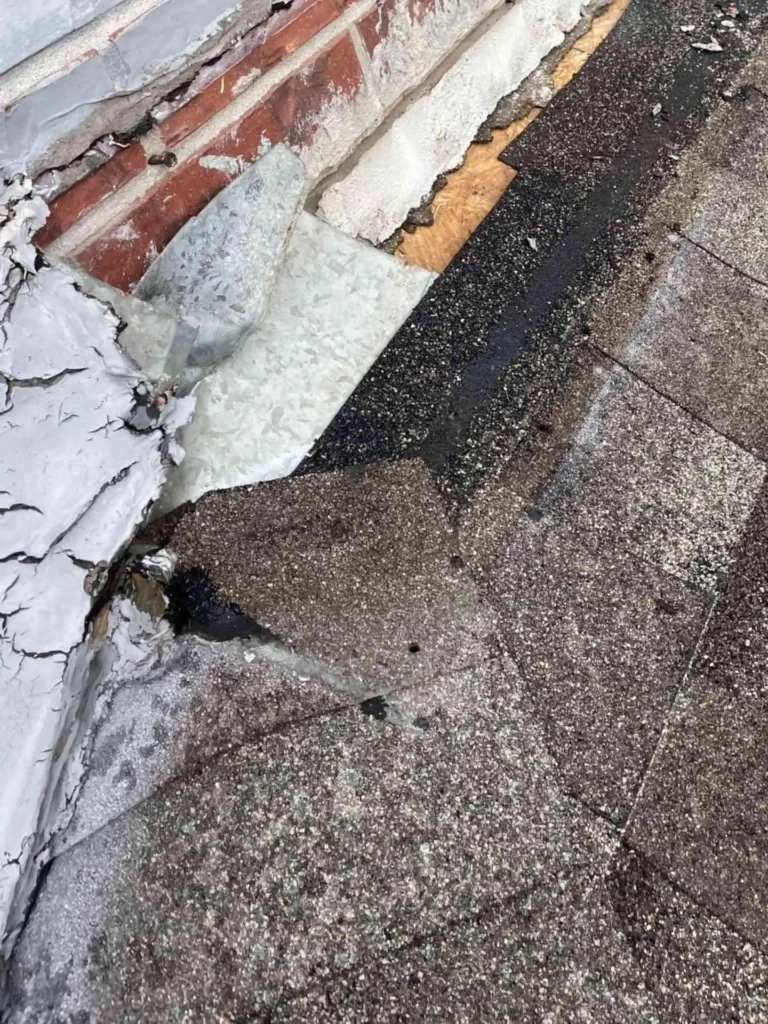 This image shows the roof-to-wall junction on a Pasadena, TX house where existing step flashing has deteriorated and clearly signals the need for counter & step flashing replacement to prevent leaks.