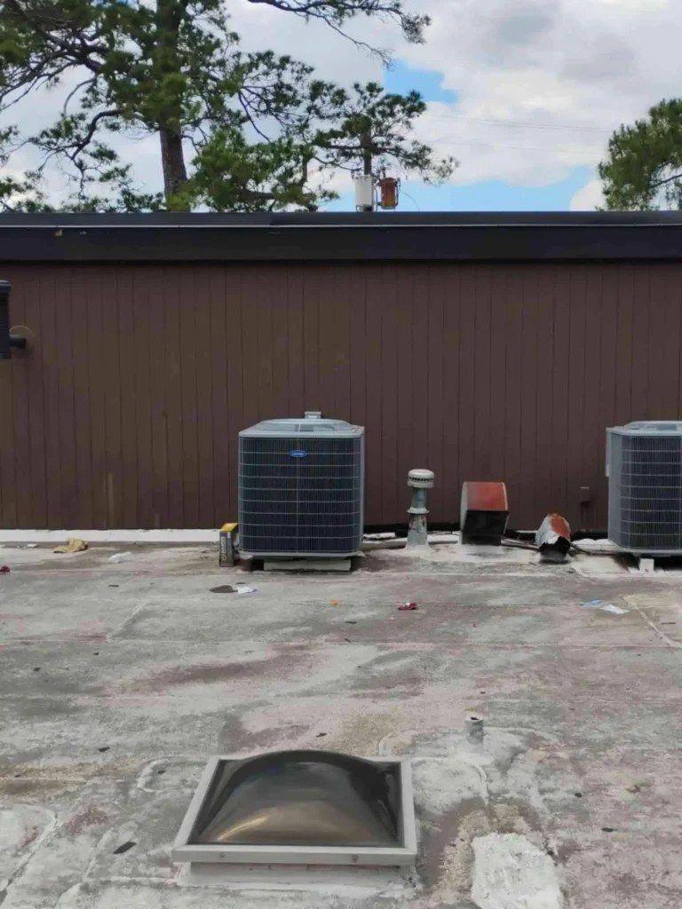 This image shows the flat roof of a Houston, TX building before retrofit work — surface looks worn, with possible damage spots and discoloration.