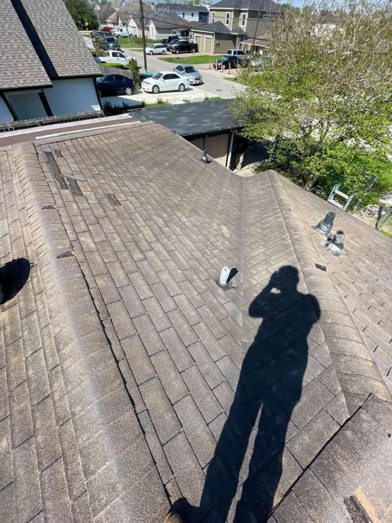 This image shows the old roof of a Houston home before replacement — damaged and worn shingles are visible, indicating the need for a full roof replacement.