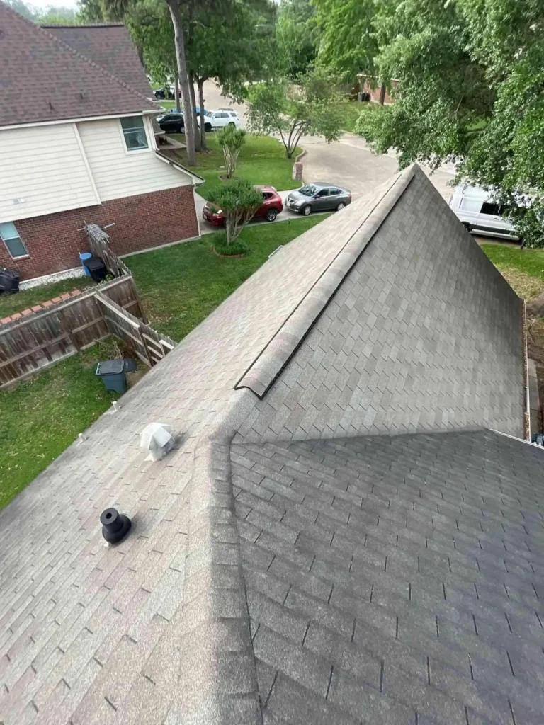 This image shows a Houston home’s roof with old, discolored shingles — the surface appears faded, indicating age and wear awaiting roof replacement.