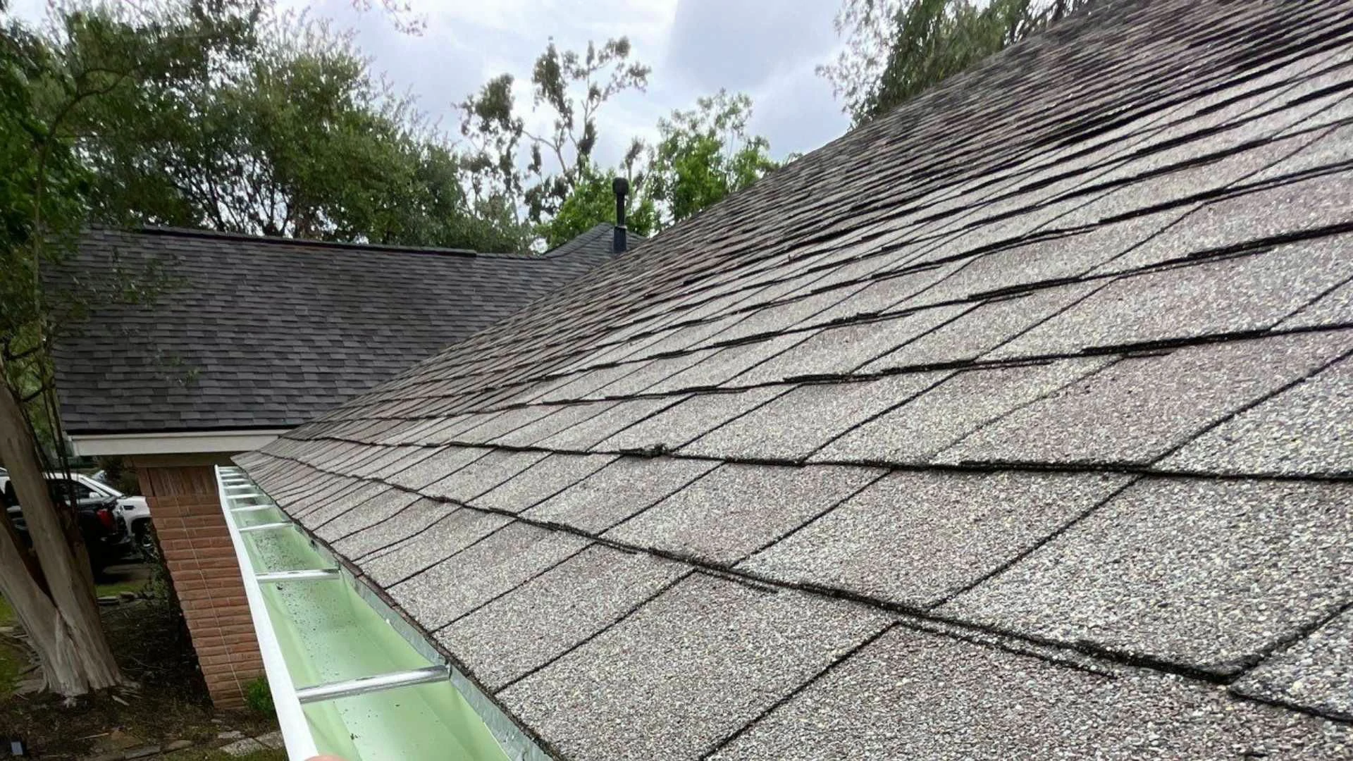 This image shows a newly installed seamless gutter system running alongside a residential shingle roof. Our Gutter Replacement service ensures superior water diversion, protecting your foundation and landscaping from damaging runoff across Houston, TX.