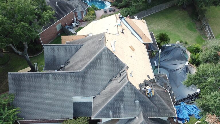 An aerial view demonstrating a significant phase of roofing work: the removal of old, damaged materials and preparation for a new roof installation. This highlights the scale of work required for high-quality service, positioning the company as one of the best roof repair specialists capable of handling full replacements and major residential projects.