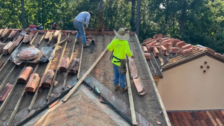 This image shows clay tile roofing in progress, roofers removing old clay tiles.