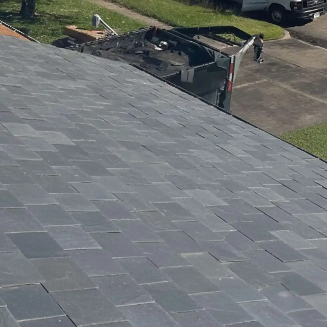 This image shows a finished slate roofing project with clean, uniform tile alignment.