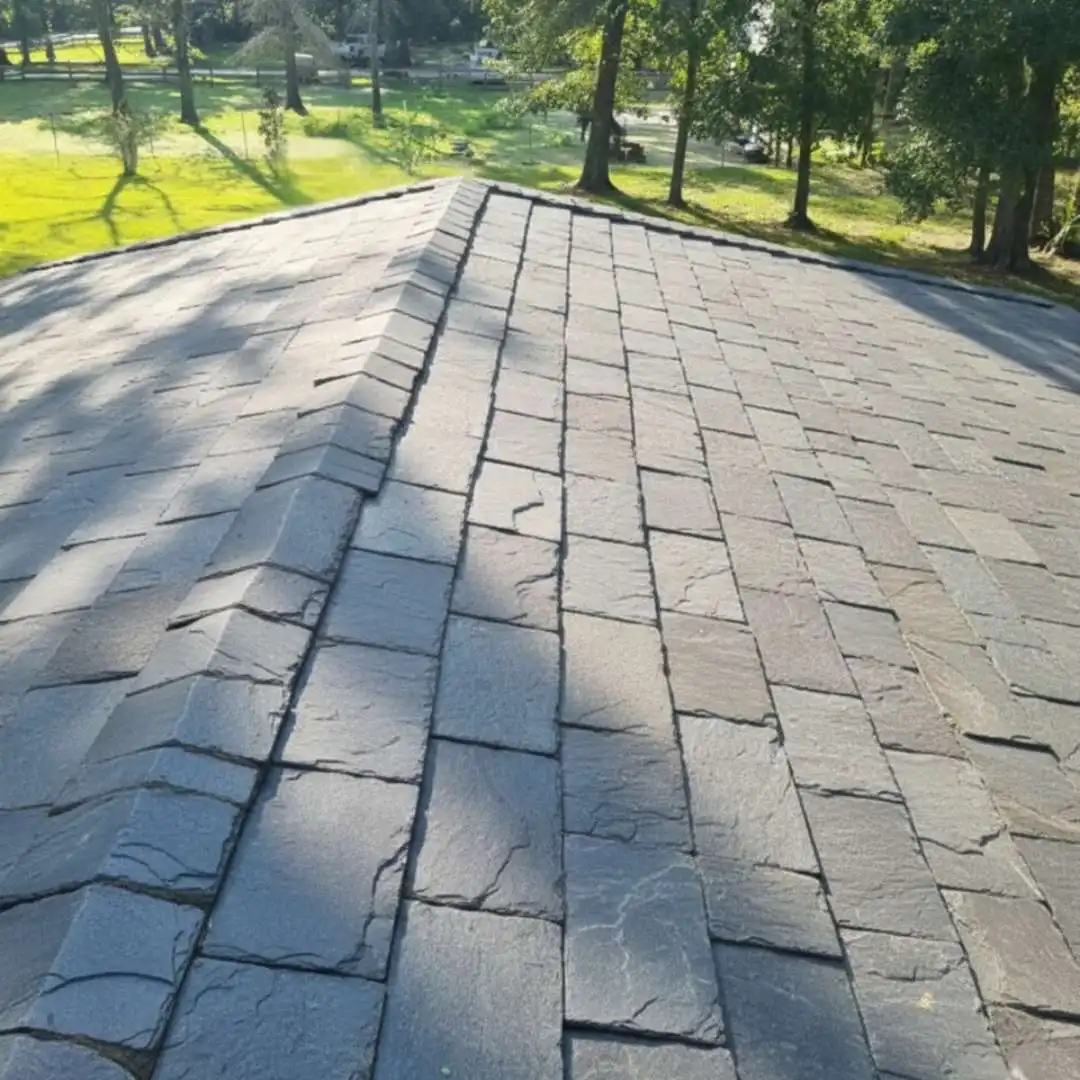 Installed grey natural slate roofing tiles on a residential roof valley by Achilles Roofing & Exterior