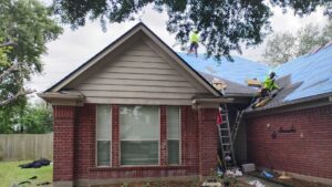 Our team at work on a brick home. Trust Achilles Roofing, a certified roofing company, to protect your home with professional installation and cleanup.