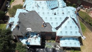 Professional roofing contractors from Achilles Roofing & Exterior performing a detailed residential roof installation using high-quality shingles.
