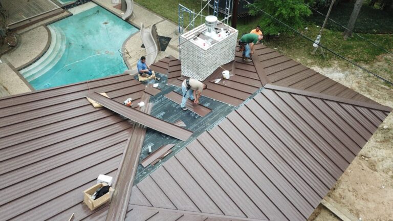 Metal Roof Components. This aerial shot captures the technical layering required for a high-performance system. By showcasing the transition from underlayment to finished panels, we highlight how critical metal roof components, such as fasteners and seam closures, are integrated to create a durable, weather-tight barrier for your home.