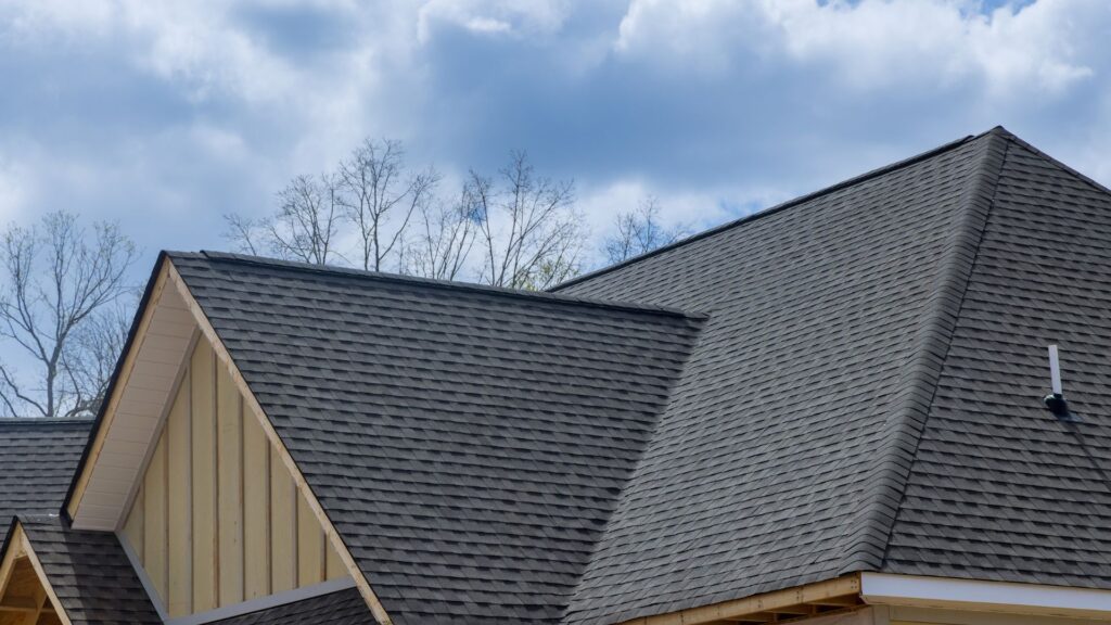 An aerial view showing the process of how to install architectural shingles over plywood decking and underlayment.