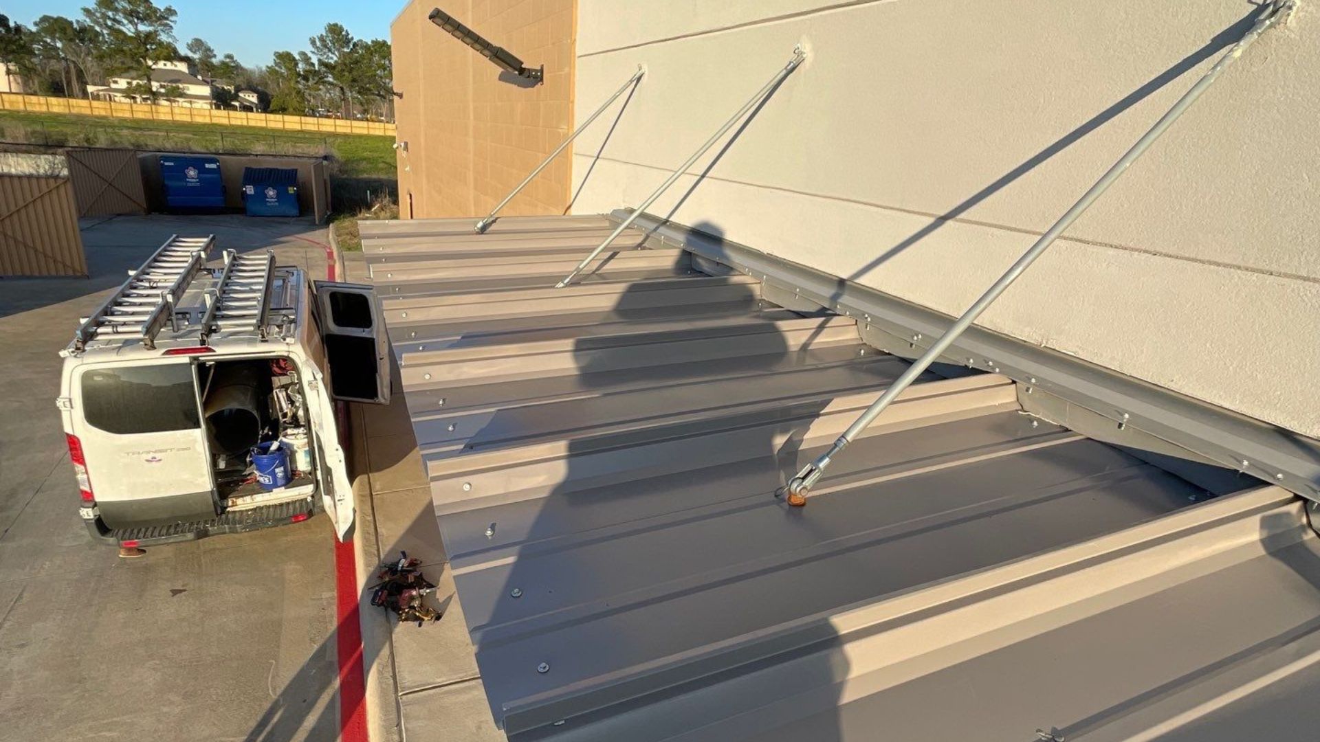 Achilles Roofing Houston team staging structural rod supports and tie back alignments during a commercial canopy installation.