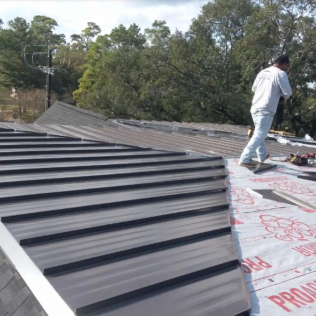 Roofing contractors installing standing seam panels during a metal roof retrofit by Achilles Roofing & Exterior